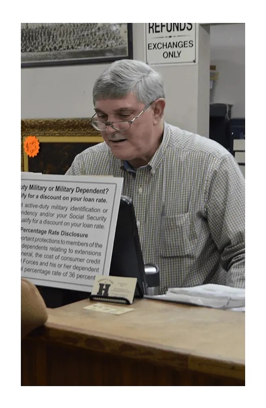 fire-guarantee A man looking at the firearms displayed at Howards Pawn & Jewelry